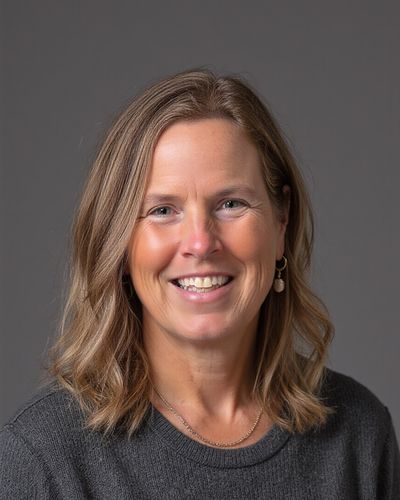 Tracy-Lynn Bergeron, smiling, in a gray sweater